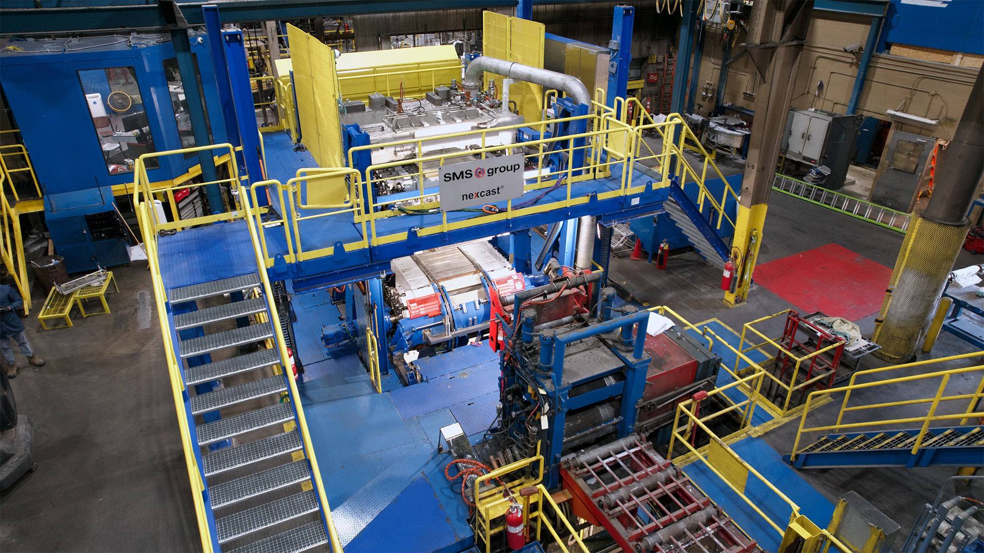 Overhead view of the Nexcast® continuous caster at Golden Aluminum with blue and yellow platforms, stairs and equipment.